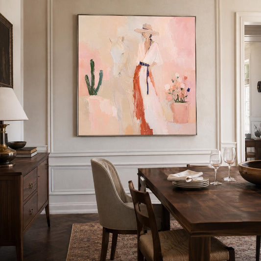 May include: A square wall painting featuring an impressionistic scene with a person in a wide-brimmed hat and a long dress, standing beside a white horse. The composition includes a green cactus and a potted plant against a soft pink background.