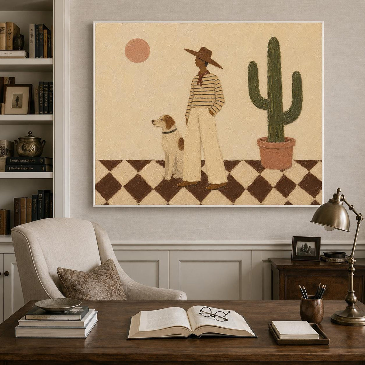 May include: A framed wall art print featuring a person in a wide-brimmed hat, striped shirt, and light pants standing next to a dog on a brown and white checkered floor. A tall green cactus in a pot and a round sun are set against a beige background.