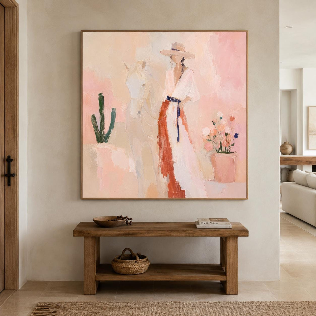 May include: A square wall art painting featuring a person in a wide-brimmed hat and a long dress standing beside a white horse. The scene includes a green cactus and a potted plant with pink flowers against a soft, peach-toned background.