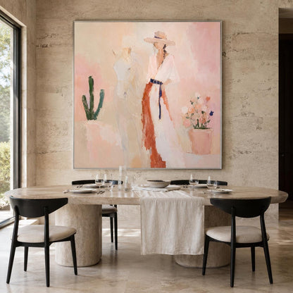 May include: A large square painting in a silver frame featuring an abstract scene with a person wearing a wide-brimmed hat and a long white dress with a dark belt, standing next to a white horse, a green cactus, and a pot of colorful flowers.